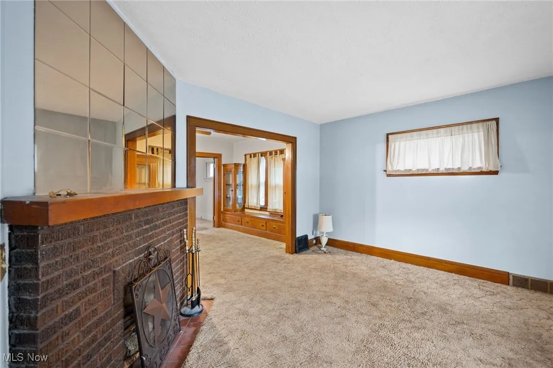 Unfurnished living room with carpet, a fireplace, and a textured ceiling