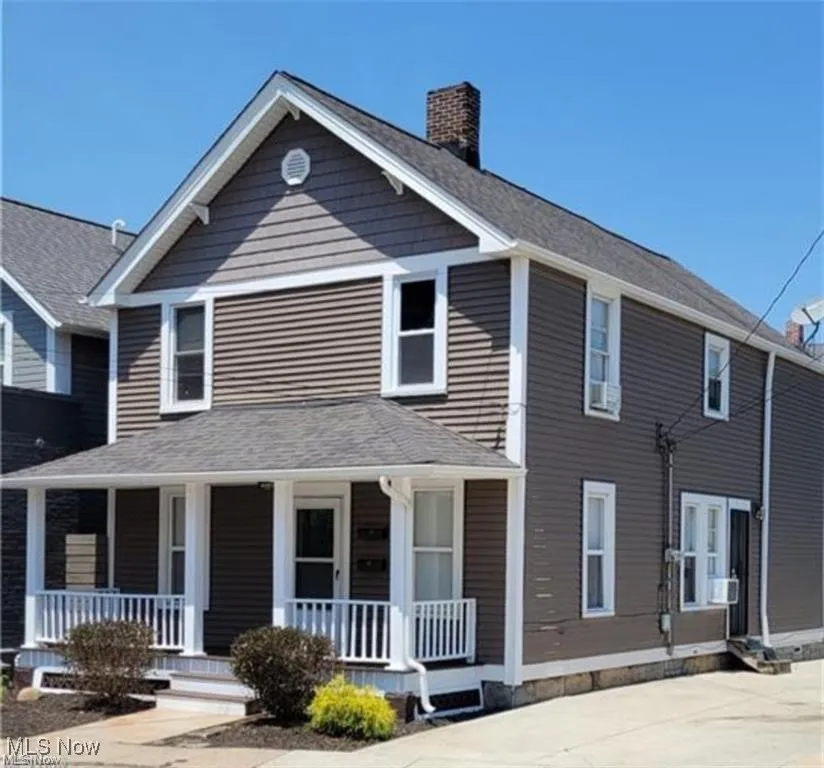 View of front of home with a porch and a chimney