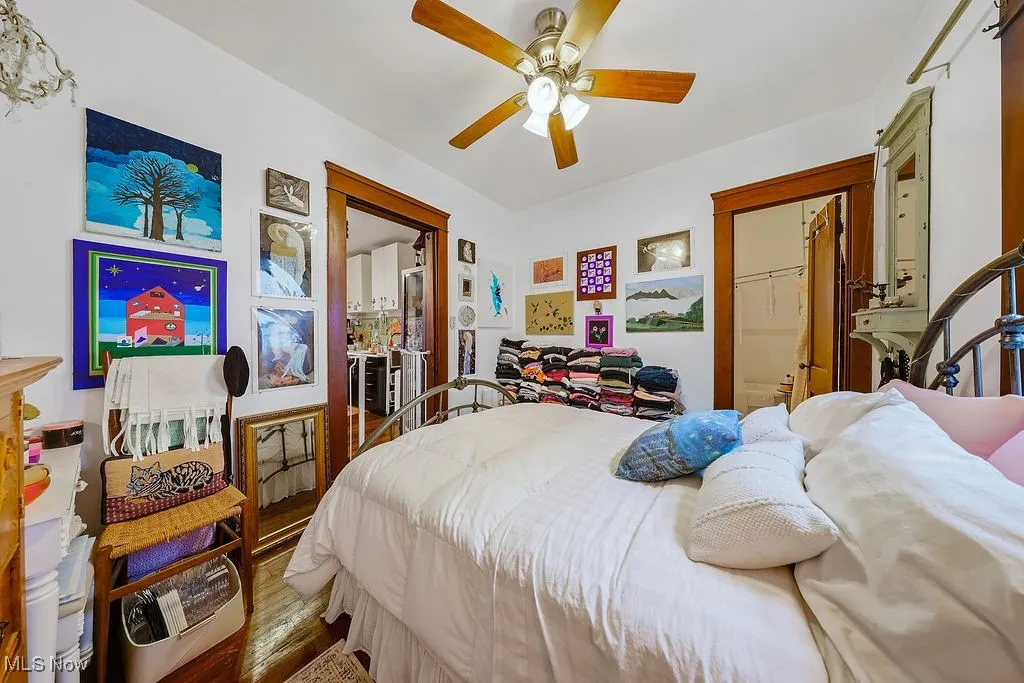 First floor unit bedroom featuring wood finished floors and a ceiling fan