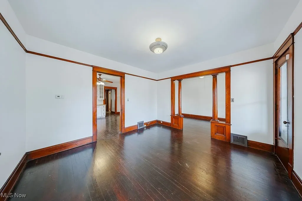 Second floor unit living room featuring baseboards and dark wood-type flooring