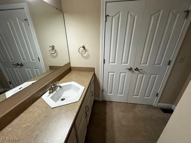 Bathroom featuring vanity and dark carpet