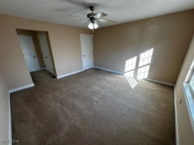 Spare room featuring carpet flooring and a ceiling fan