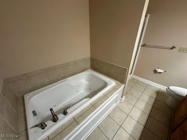 Bathroom featuring a jetted tub and light tile patterned flooring