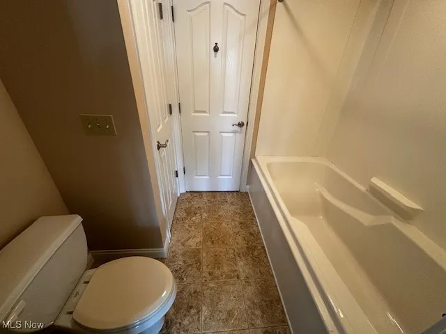 Bathroom featuring toilet and baseboards