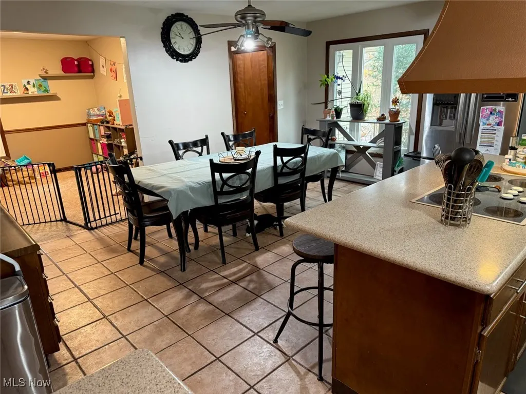 Dining area with light tile patterned floors and ceiling​​‌​​​​‌​​‌‌​‌‌​​​‌‌​‌​‌​‌​​​‌​​ fan