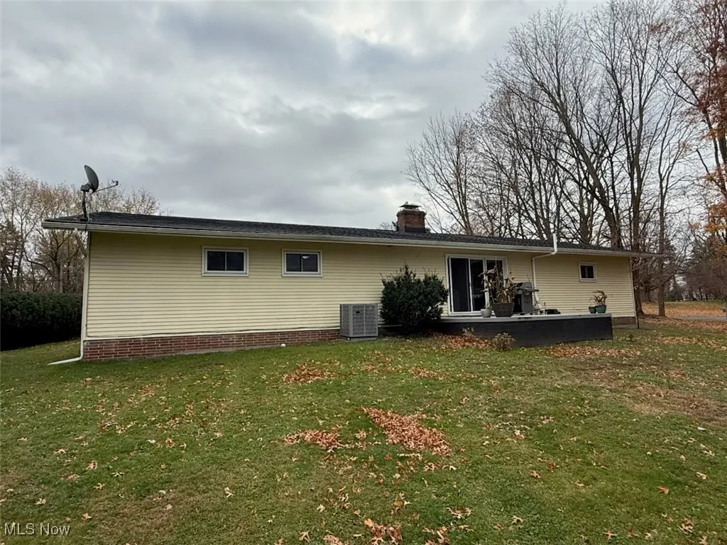 Rear view of property with a yard and a chimney