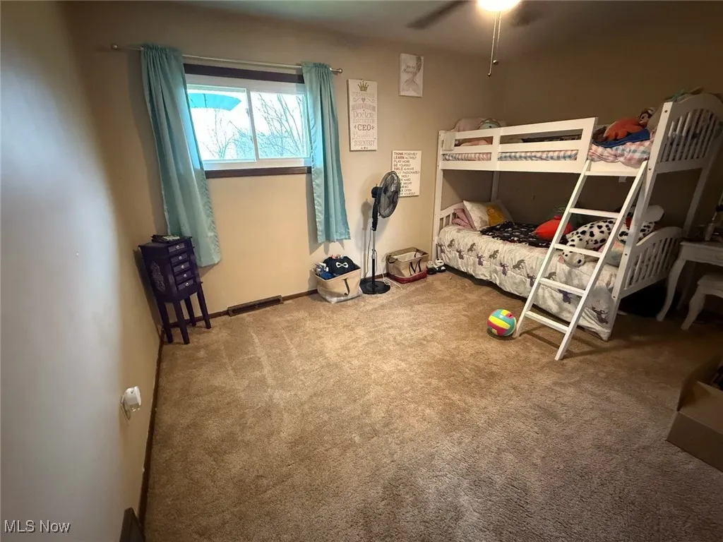Unfurnished bedroom featuring carpet and a ceiling fan