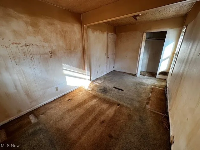 Unfurnished bedroom featuring a closet and a textured ceiling