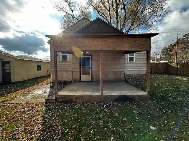 Rear view of house featuring a patio area and a lawn