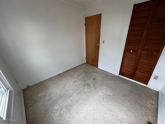 Unfurnished bedroom featuring carpet and a closet