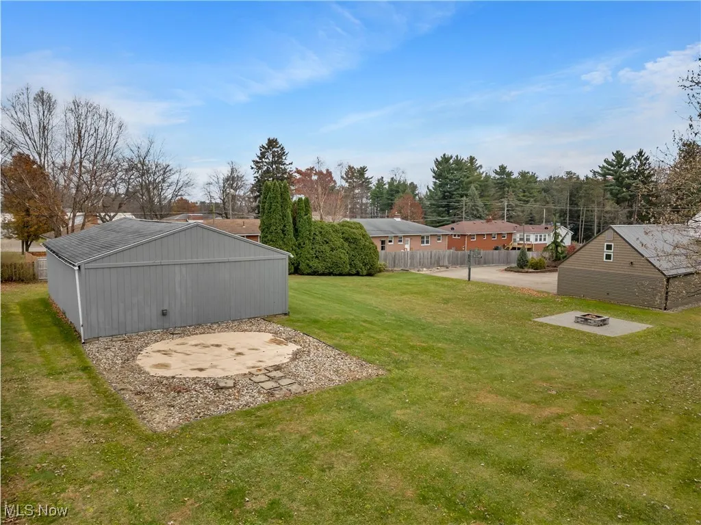 View of yard with a patio, a fire pit, and an outbuilding