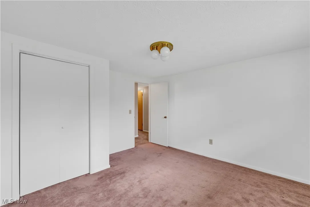 Unfurnished bedroom with carpet, a closet, and a textured ceiling