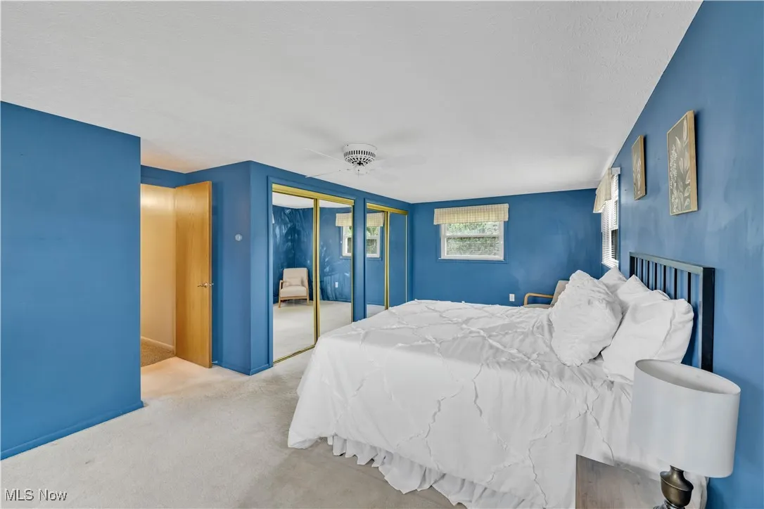 Bedroom with carpet, a ceiling fan, and a textured ceiling
