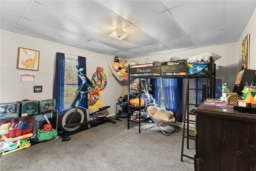 Bedroom featuring carpet flooring and wooden walls