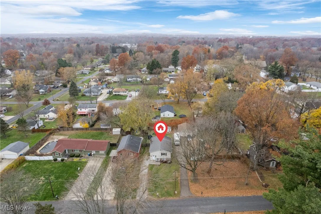 Aerial view of property and surrounding area featuring nearby suburban area