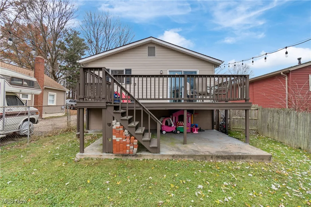 Back of house featuring a fenced backyard, stairs, a patio area, and a deck