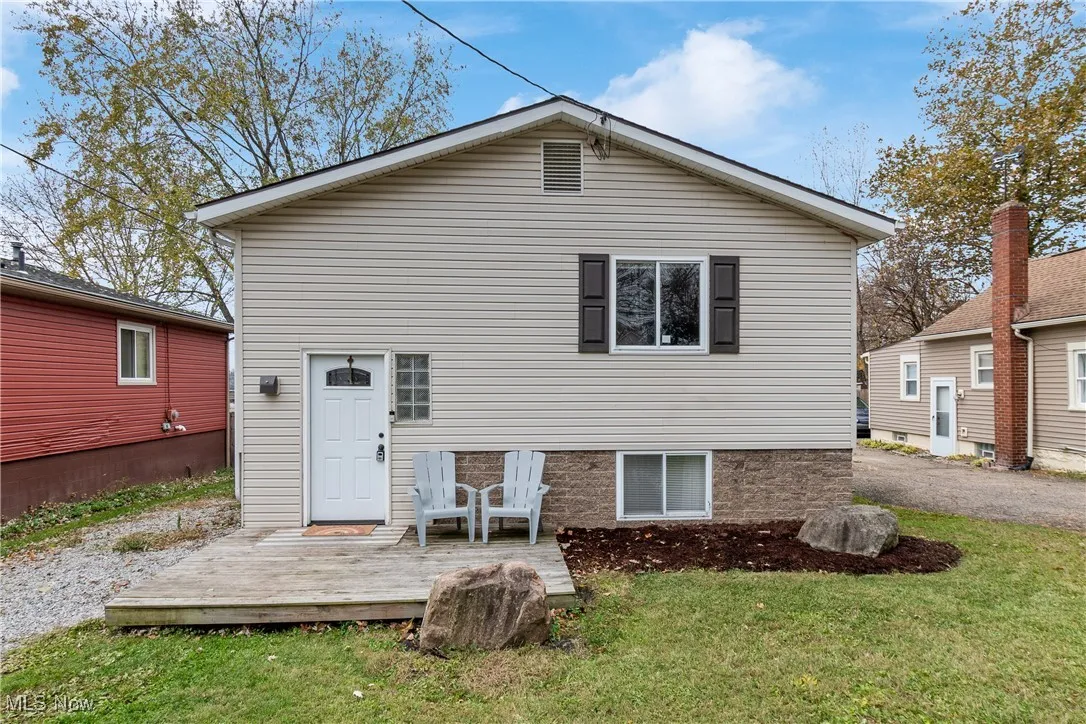 Rear view of house with a yard and a wooden deck