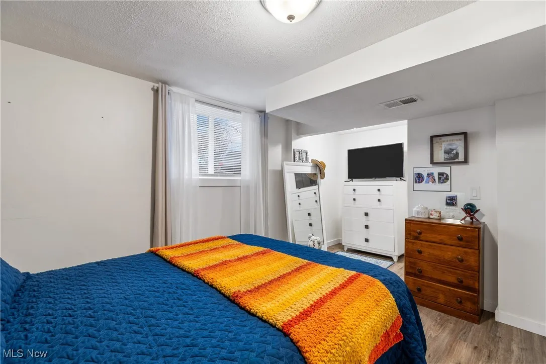 Bedroom featuring a textured ceiling and wood finished floors