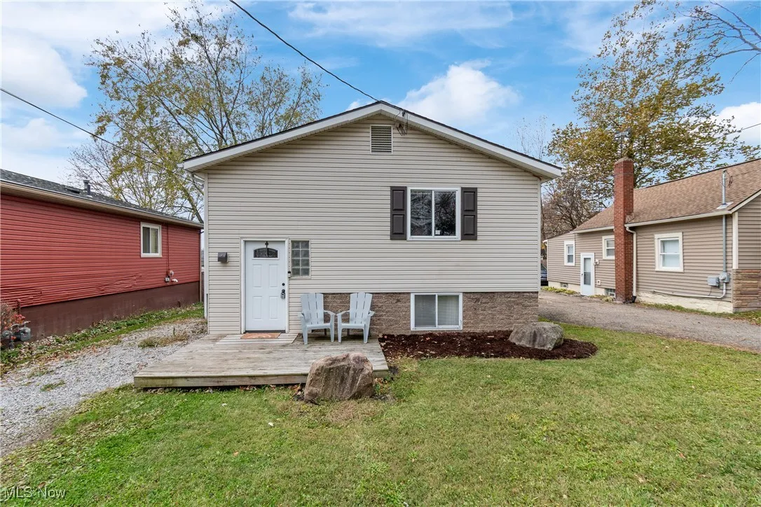 Rear view of house with a yard and a deck