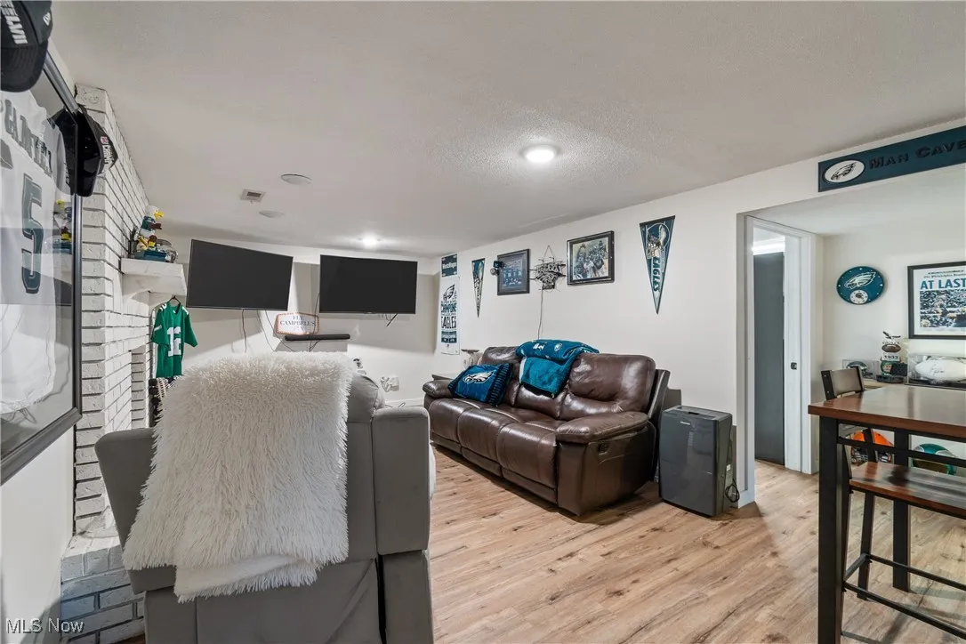 Living room with light wood-style floors and a textured ceiling