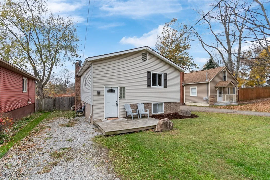 Back of property with a chimney and a wooden deck