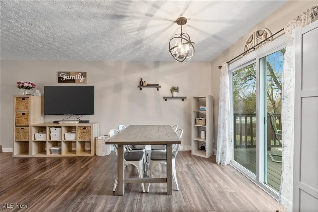 Dining area featuring wood finished floors, a textured ceiling, and a chandelier
