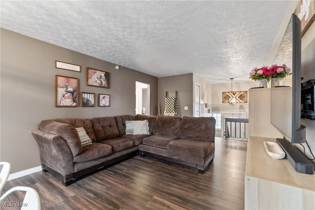 Living area featuring dark wood-style floors and a textured ceiling
