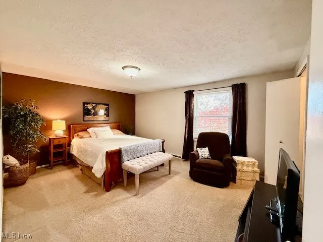 Very large upstairs 2nd  carpeted bedroom with a textured ceiling and walk-in closet.