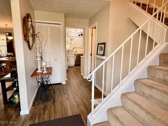 Staircase with a textured ceiling, LVP waterproof dark walnut finished floors.