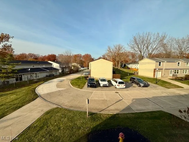 View of community with a residential view of extra guest parking directly across from condominium.