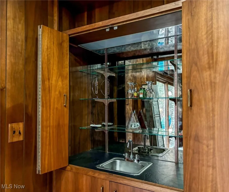Family Room wet bar featuring mirrors, glass shelving and sink