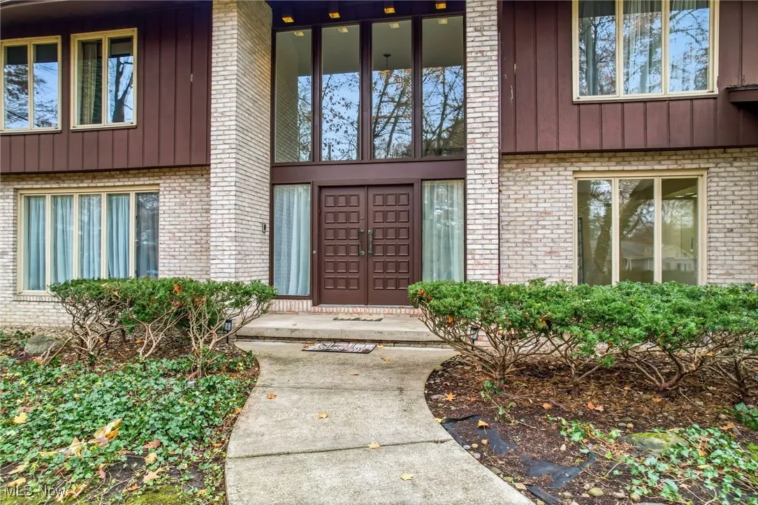 Property entrance with brick and cedar. beautiful windows letting in lots of natural light
