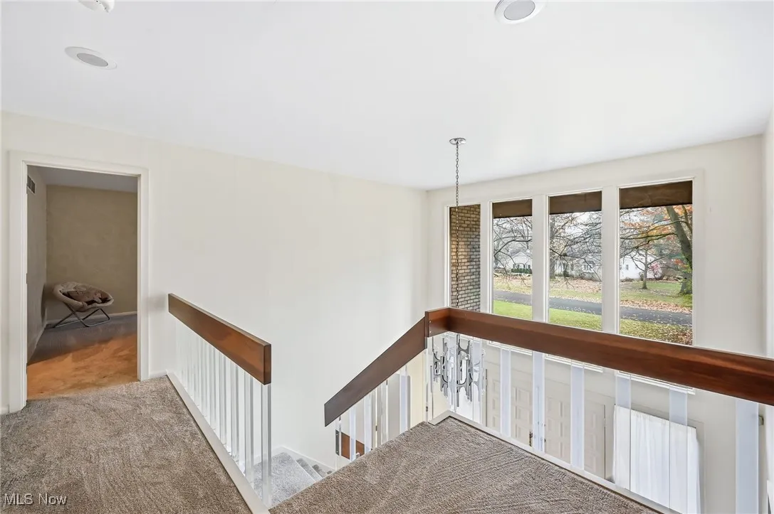 Hall featuring carpet and an upstairs landing area