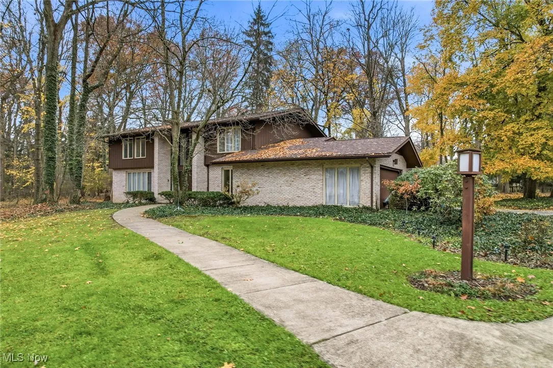 View of front facade with a front lawn and brick