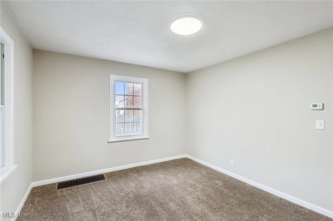 Carpeted empty room with baseboards