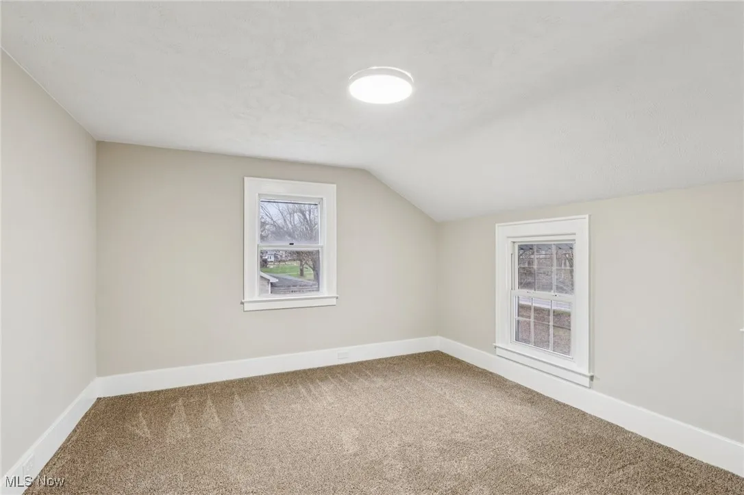 Additional living space with carpet, lofted ceiling, and a textured ceiling