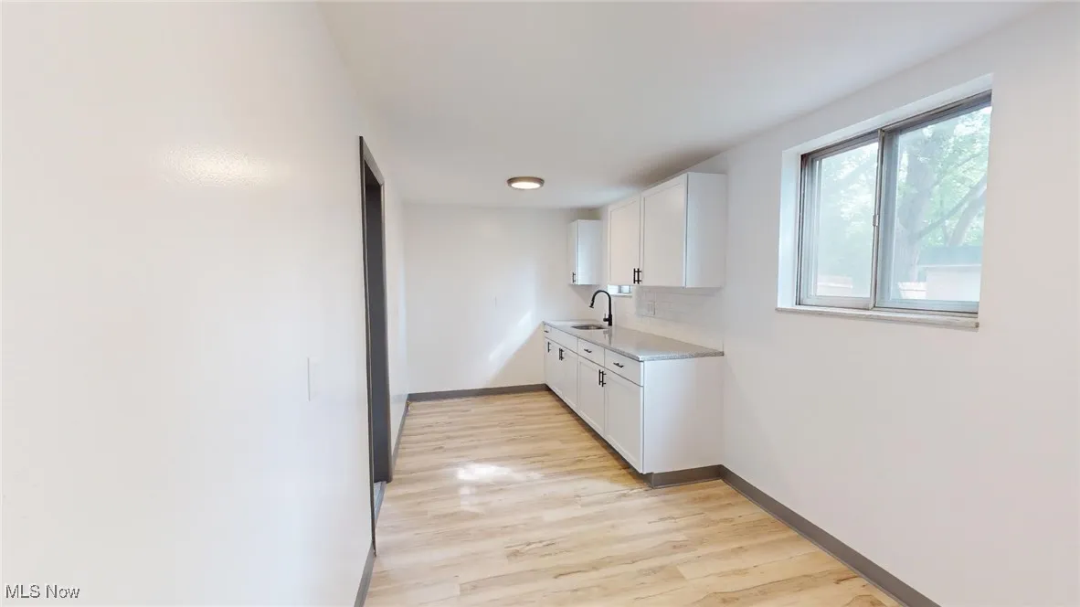 Kitchen featuring light countertops, white cabinets, and light wood-style floors