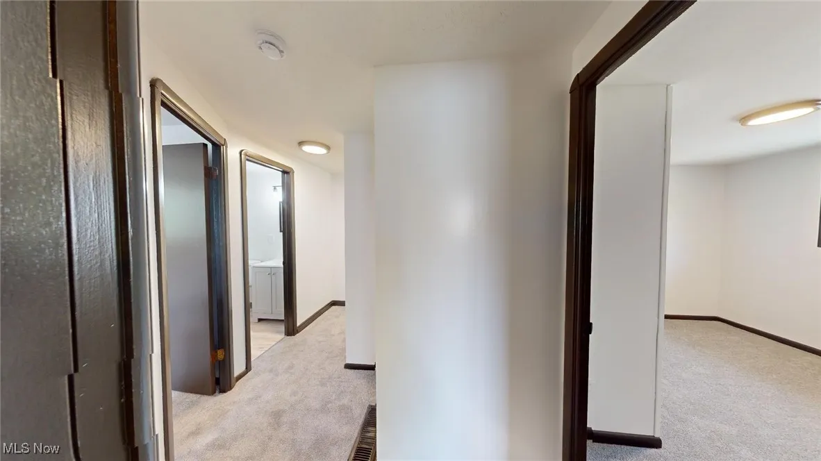 Corridor with light carpet and baseboards