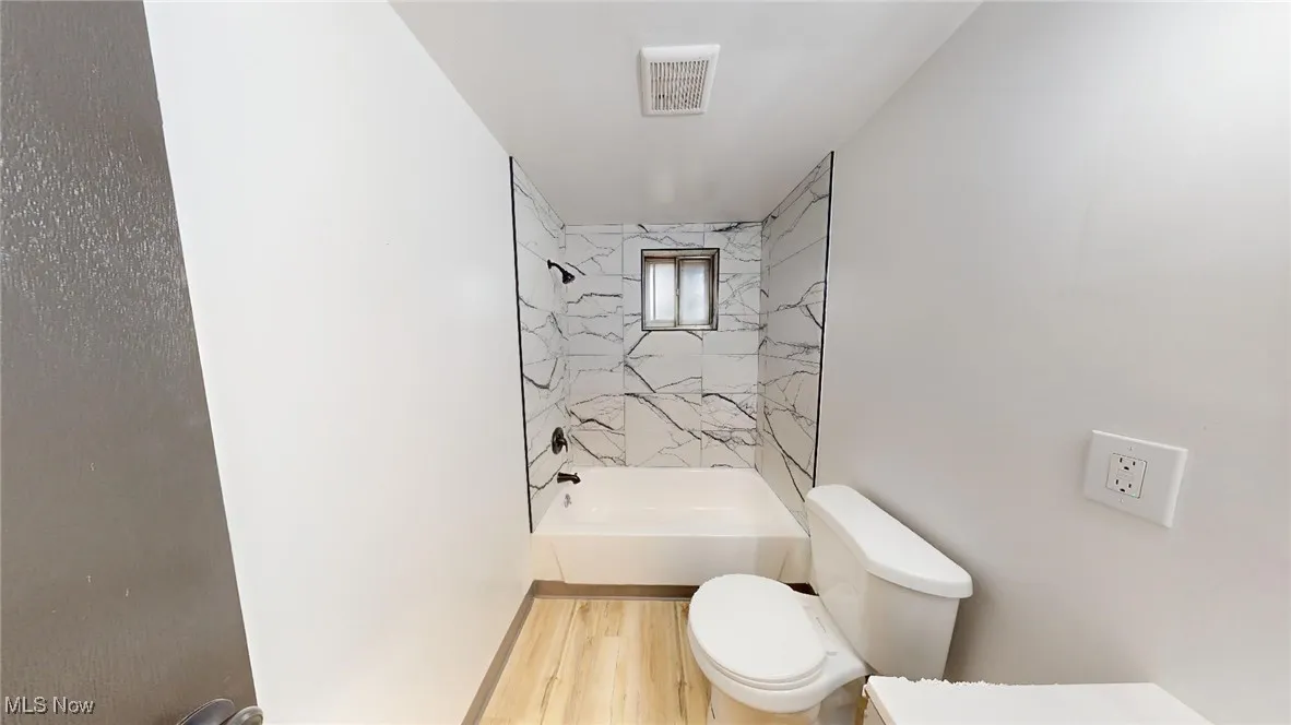 Bathroom featuring tub / shower combination and wood finished floors