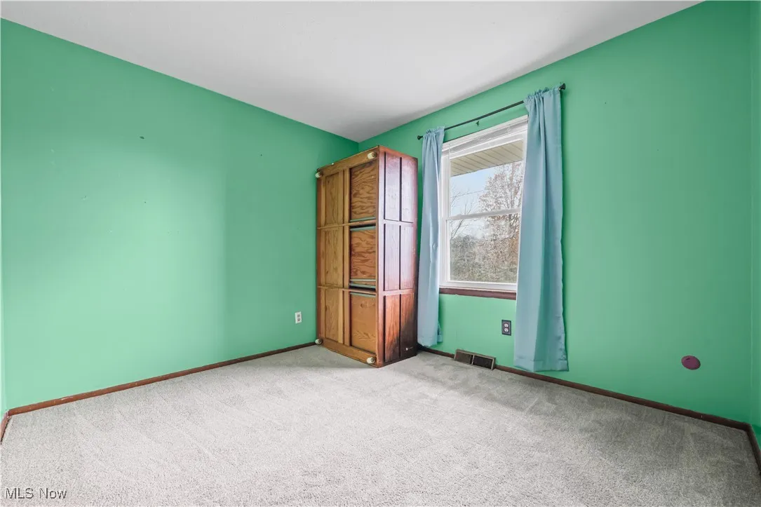 Empty room featuring carpet and baseboards
