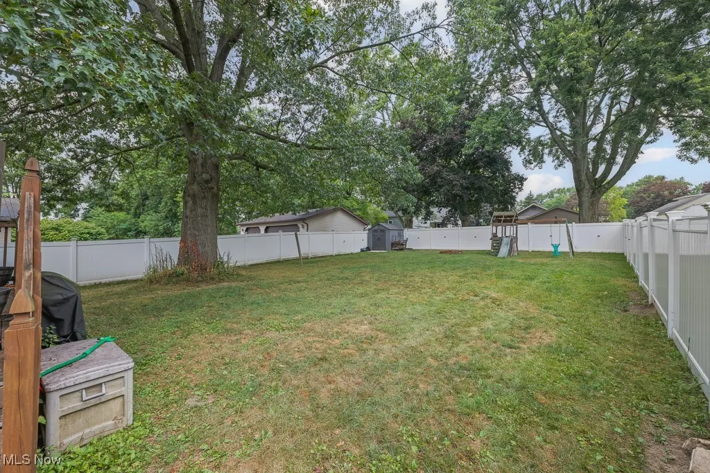 Fenced backyard featuring a playground