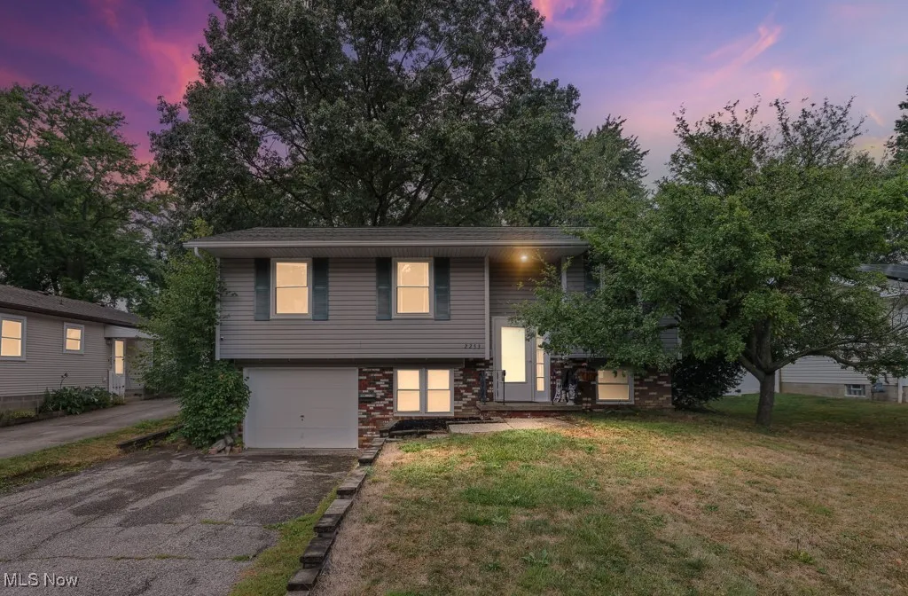 Bi-level home featuring a lawn, asphalt driveway, and a garage