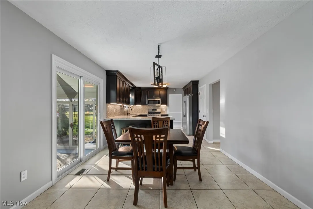 Dining space featuring light tile patterned flooring and a textured ceiling