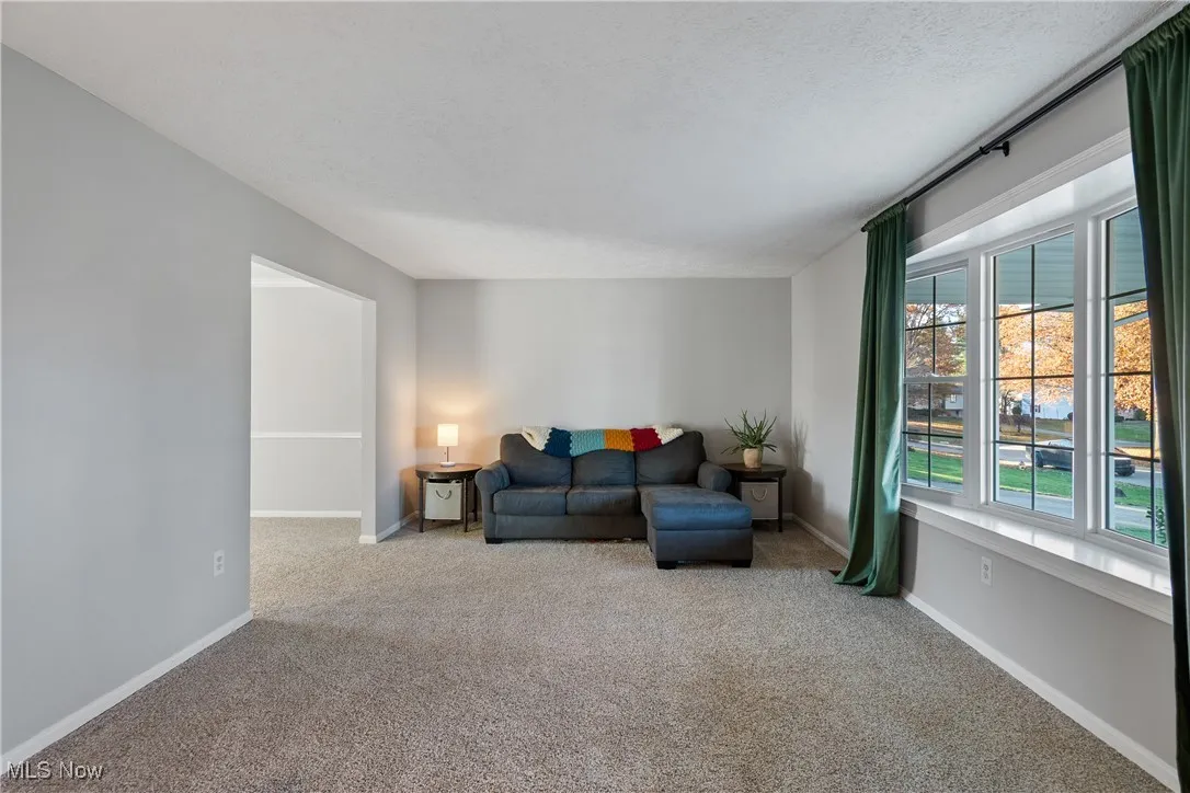 Living area with carpet floors and a textured ceiling