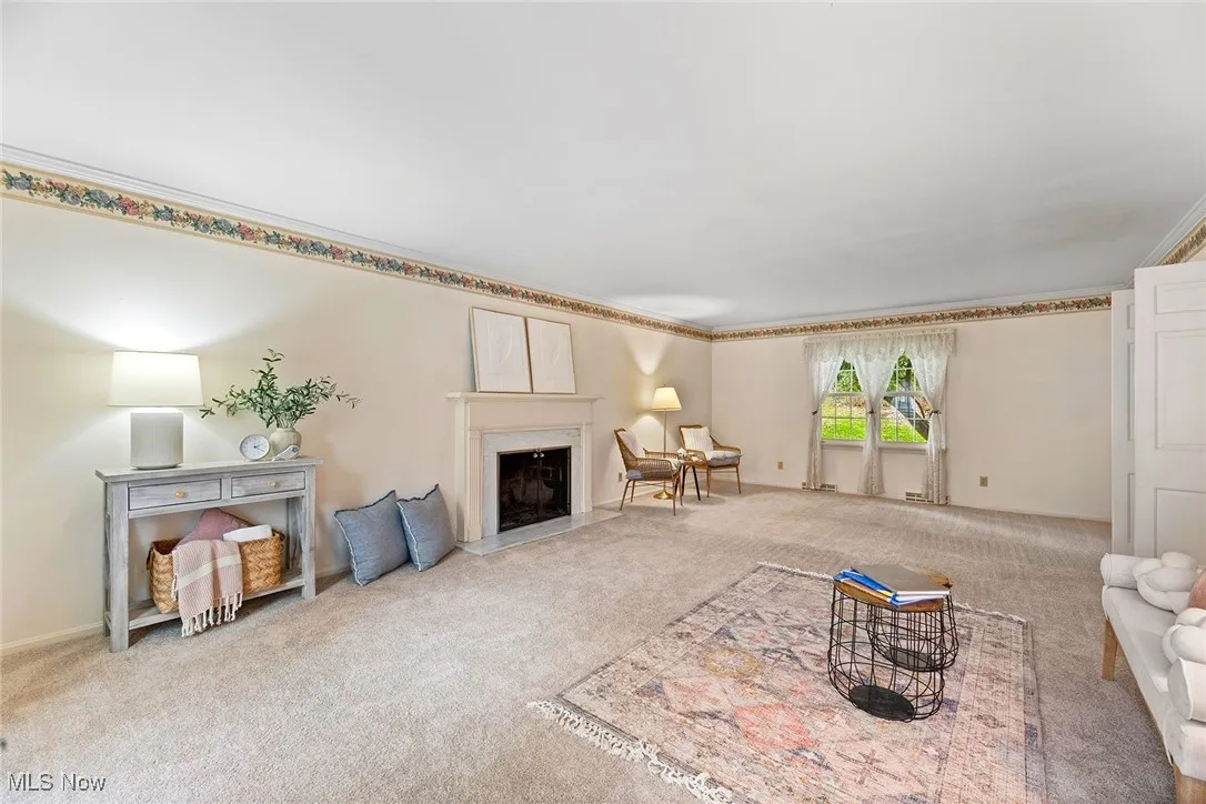 Living area with carpet and a fireplace with flush hearth