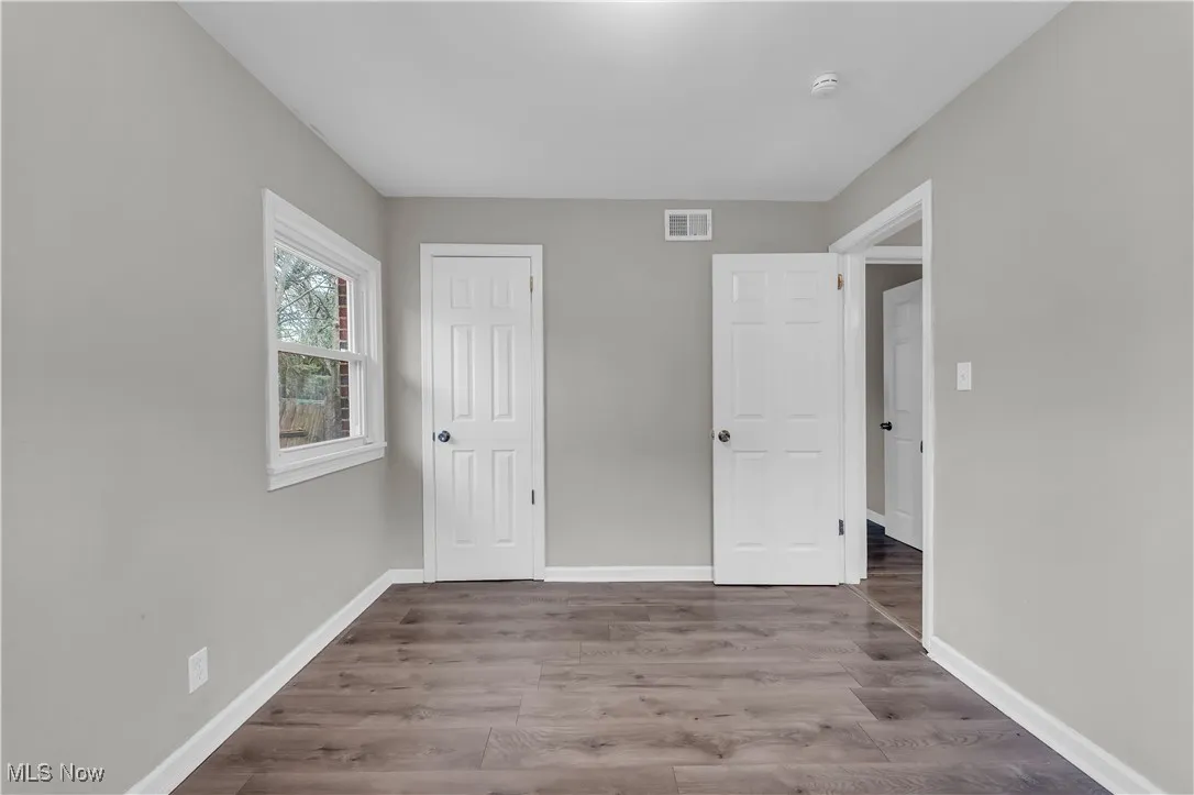Unfurnished bedroom featuring dark wood finished floors and a closet