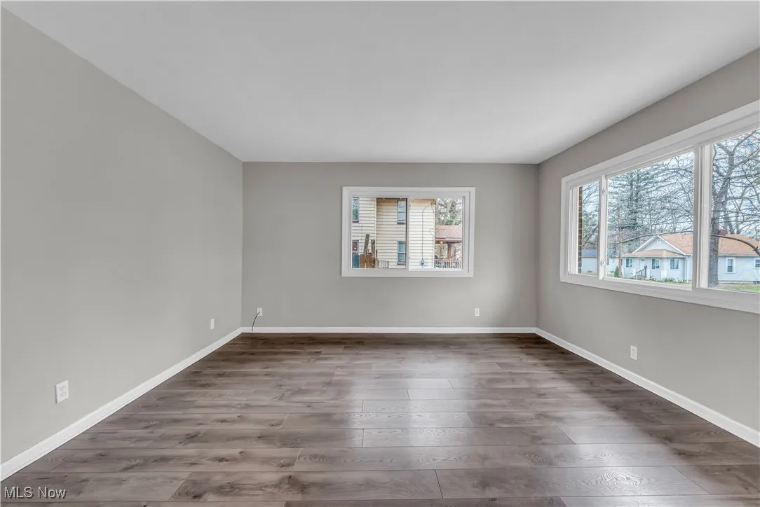 Unfurnished room with dark wood-type flooring