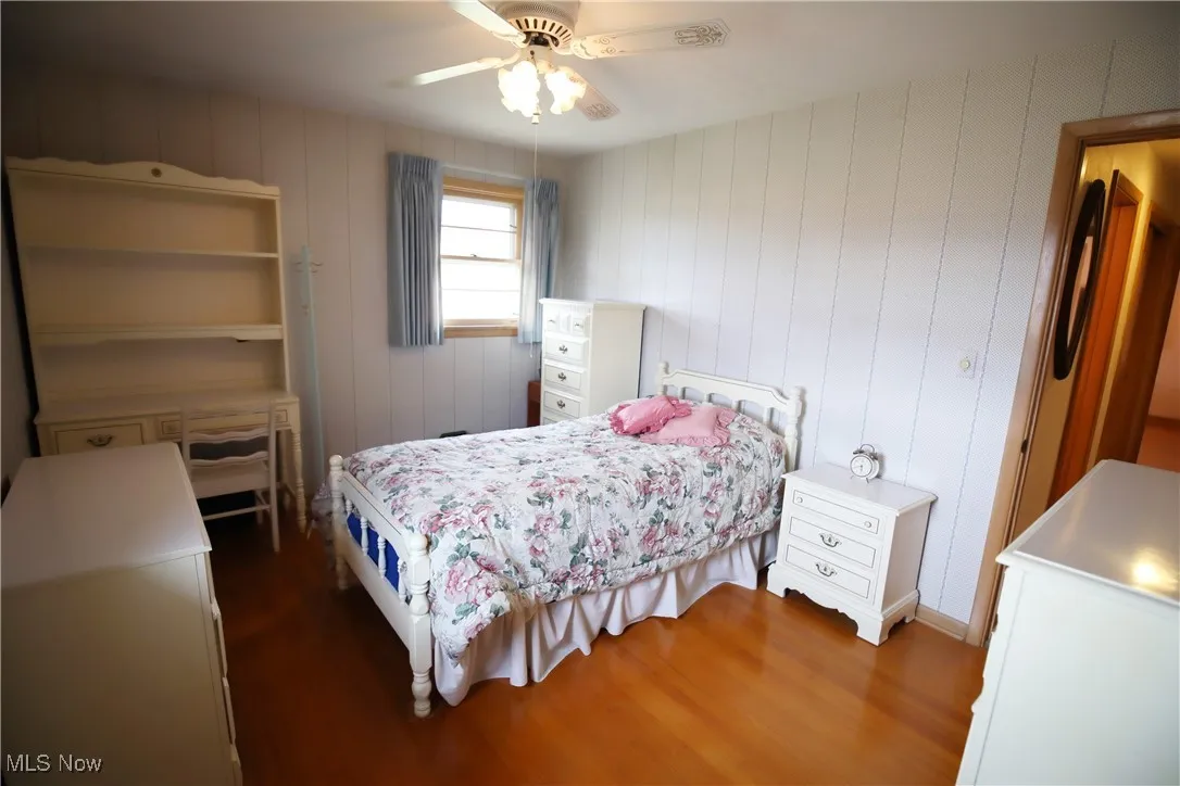 Bedroom with dark wood-style flooring and a ceiling fan