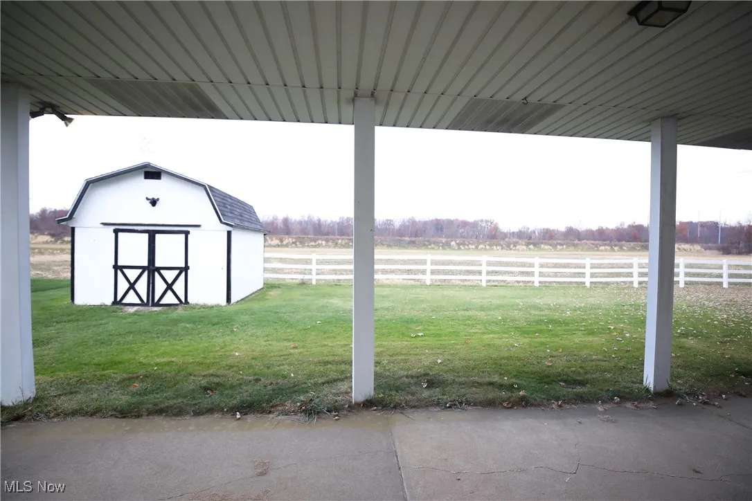 View of yard with a patio, a storage unit, and a rural view
