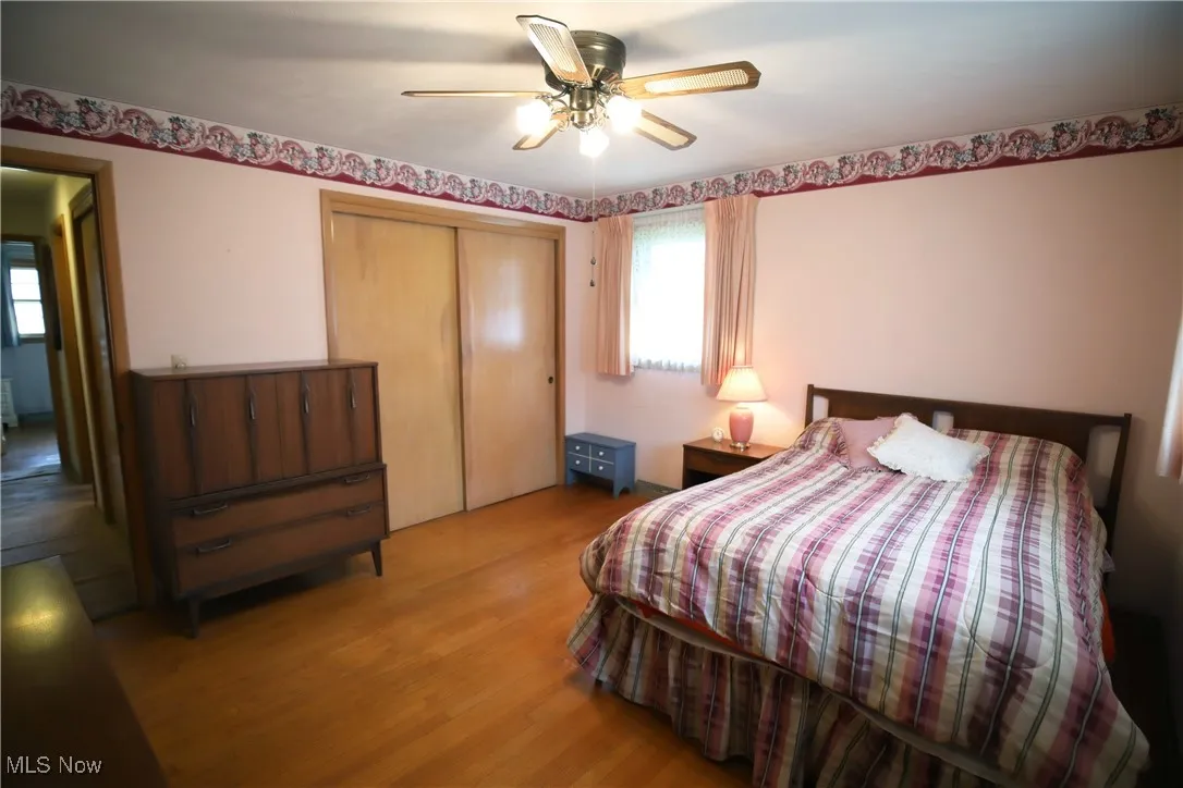 Bedroom featuring a closet, wood finished floors, and a ceiling fan